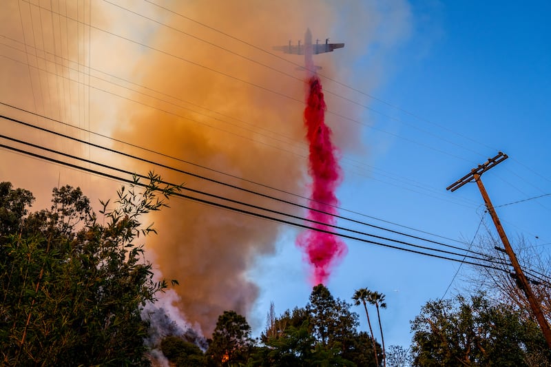 An aircraft drops fire retardant on the Palisades fire in Mandeville Canyon, in Los Angeles, on Saturday. Photograph: Loren Elliott/The New York Times