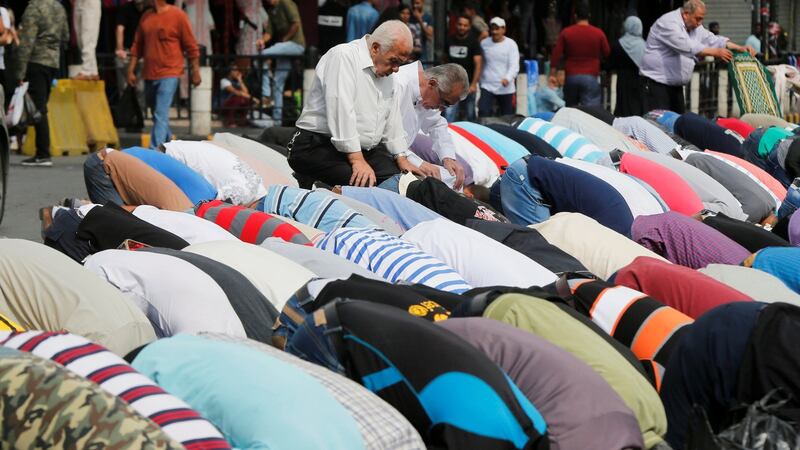 Men say Friday prayers on a street outside al-Husainy mosque in Amman. Photograph: Muhammad Hamed/Reuters