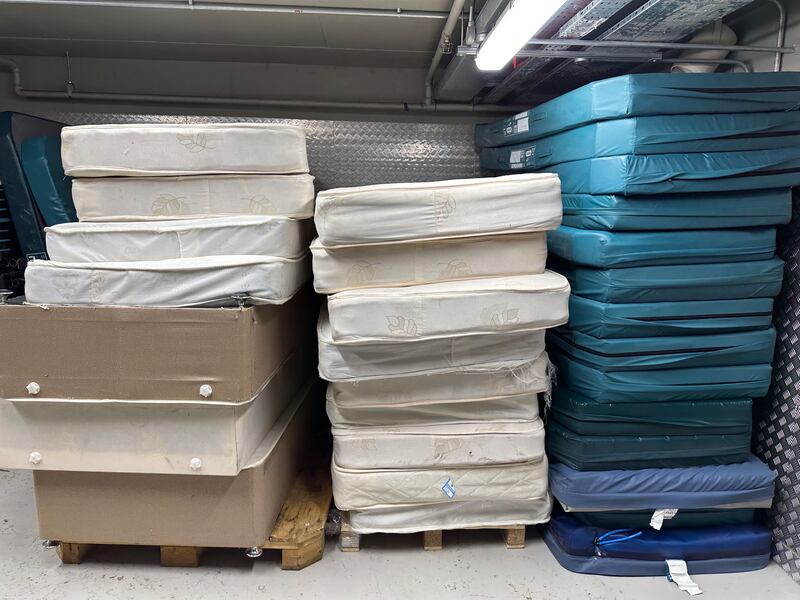 Unwanted mattresses from nursing homes and boxes of surgical gowns and gloves line the corridors in the warehouse