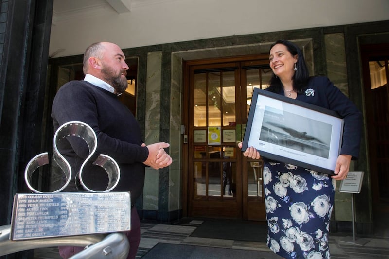 James Crombie presents a framed version of his photograph of a murmuration of starlings to Minister for Culture Catherine Martin. Photograph: Paul Sherwood