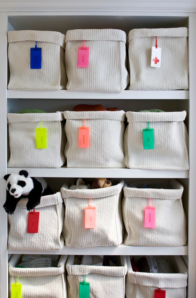 White woven storage baskets with individual labels for organizing a child’s bedroom