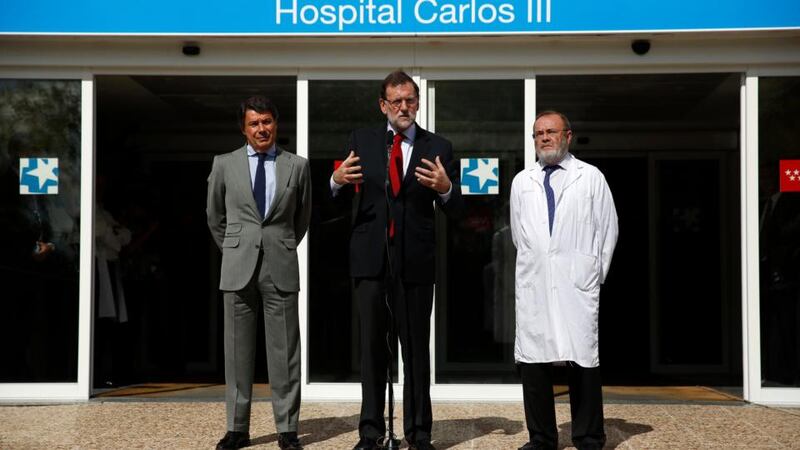 Spanish prime minister Mariano Rajoy (centre) is flanked by Madrid’s regional president Ignacio Gonzalez (left) and Rafael Perez-Santamarina, manager of Madrid’s Carlos III hospital, as he gives a statement to the media outside the hospital today. Photograph: Susana Vera/Reuters