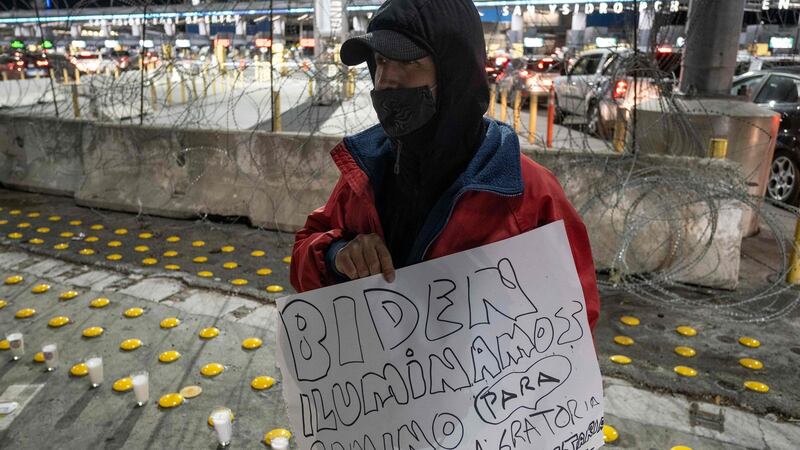 A migrant holds a sign reading “Biden: enlight the way for a humane immigration reform” at  a vigil  in Tijuana, Mexico, on Monday. Photograph: Guillermo Arias/AFP