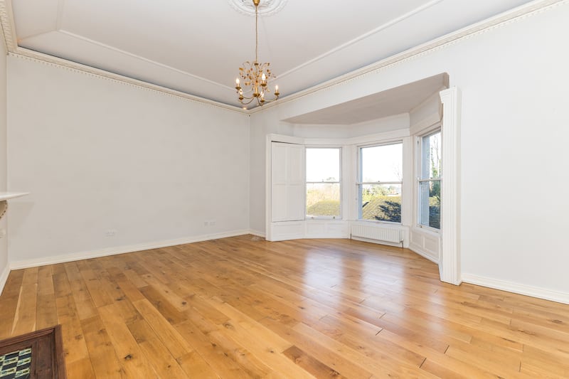 The principal bedroom has a tall ceiling and an impressive bay window