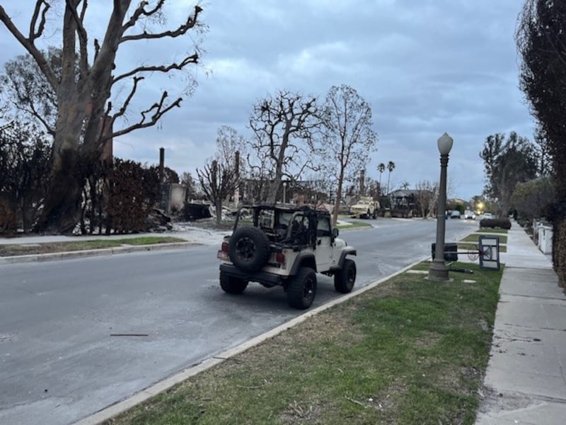 A burnt-out jeep outside destroyed homes along the Pacific Palisades. Photograph: Keith Duggan