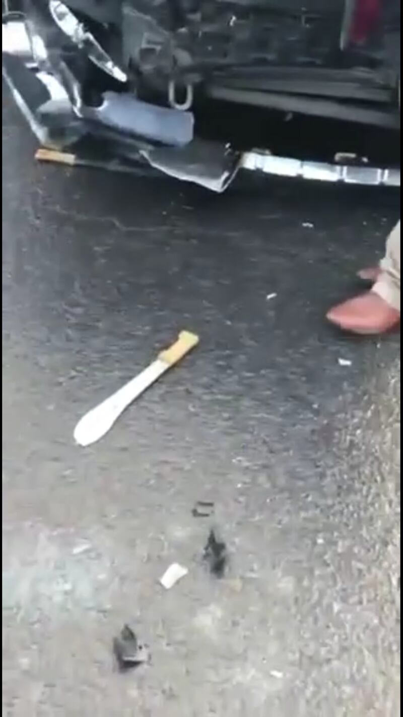 Still photo from a video of the aftermath of violence in Rathkeale showing two machetes (one near undercarriage of damaged vehicle) left on the road.


