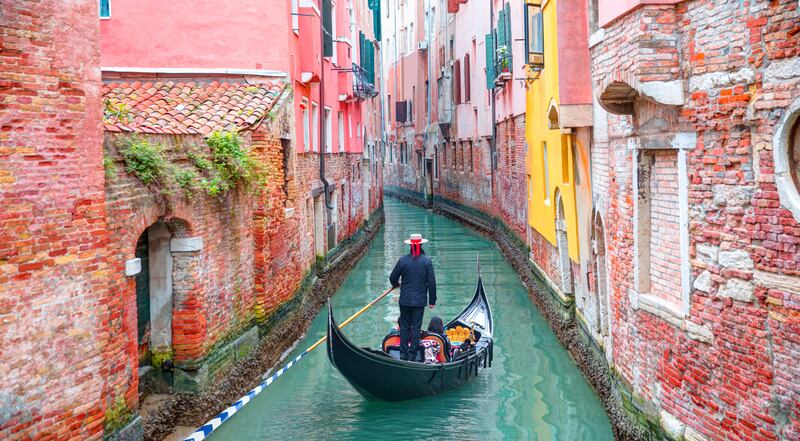 A Venetian gondolier punting through the city