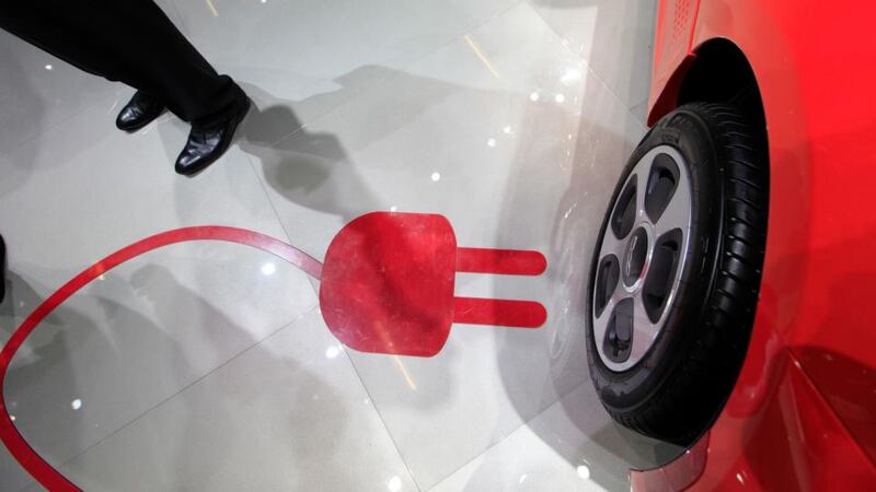 A charging plug symbol sits on the floor near the wheel of a Fiat 500e electric automobile, produced by Fiat SpA, at the 65th Frankfurt International Motor Show in Frankfurt.