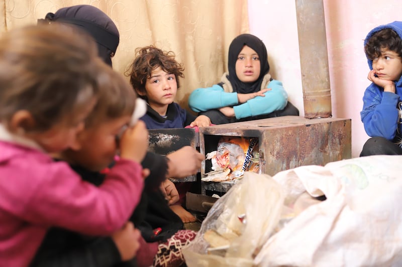 The younger members of Hamoud’s family are trying to keep warm by burning plastic, often the only heating fuel available to them. Idleb, Syria. February 2024