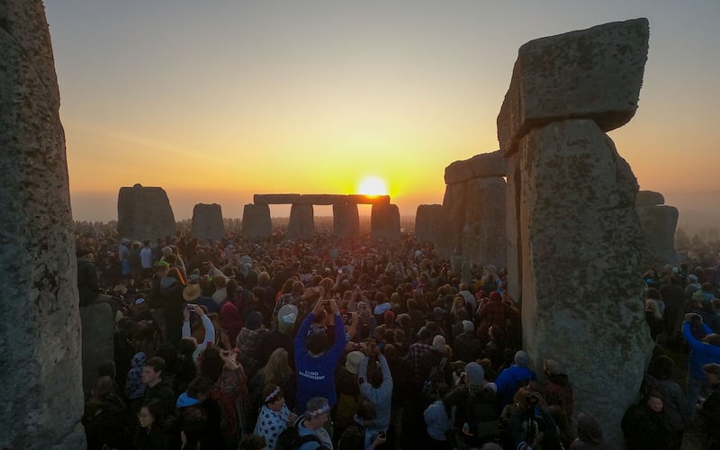 Visitors clamour to see the rising sun between the stones at Stonehenge welcome the sun at Stonehenge. Photograph: Finnbarr Webster/Getty