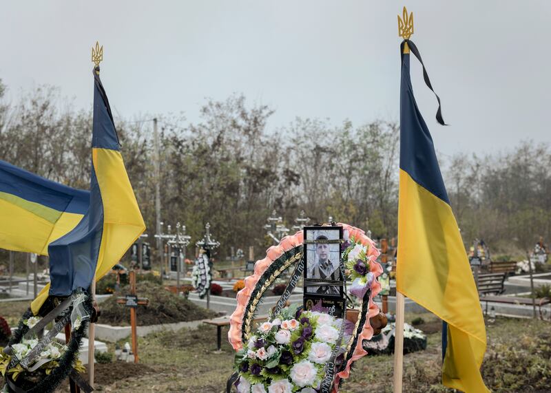 A photograph of Serhii Bolhov at his grave in Oshykhliby, Ukraine. Bolhov’s conscription and death sent a chill through the town, highlighting fears of being whisked off the streets and dying in battle. Photograph: Emile Ducke/The New York Times