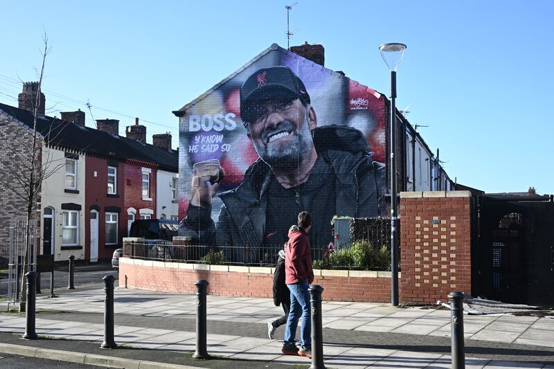 Pedestrians walk past a mural of Liverpool's German manager Jurgen Klopp near Anfield in Liverpool. Photograph: Paul Ellis/AFP via Getty Images