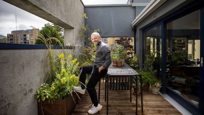 Mark Grehan in his  garden. The terrace’s outer concrete boundary walls are painted a warm shade of charcoal-grey that mirrors the interior walls of his apartment.  Photograph: Tom Honan