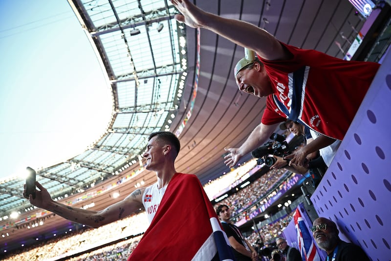 Jakob Ingebrigtsen celebrates gold draped in his national flag after the 5,000m final at the Paris Olympics. Photograph: Anne-Christine Poujoulat/AFP via Getty Images