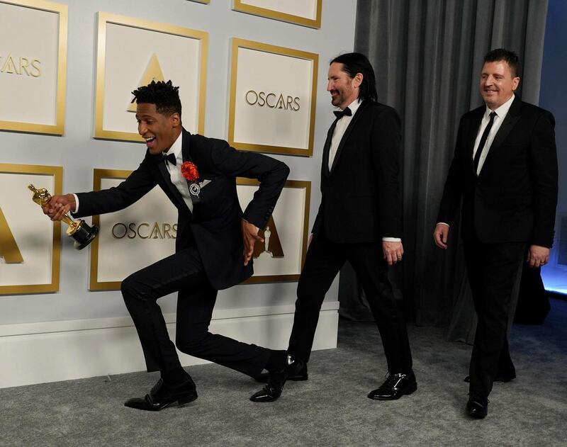 Jon Batiste, from left, Trent Reznor and Atticus Ross, winners of the award for best original score for "Soul," pose in the press room at the Oscars on Sunday, April 25, 2021, at Union Station in Los Angeles. (AP Photo/Chris Pizzello, Pool)