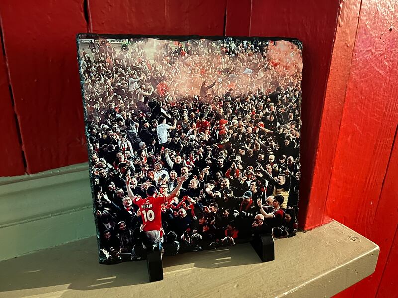 The iconic photo of Wrexham star striker Paul Mullin celebrating with fans, framed and on a shelf in the pub