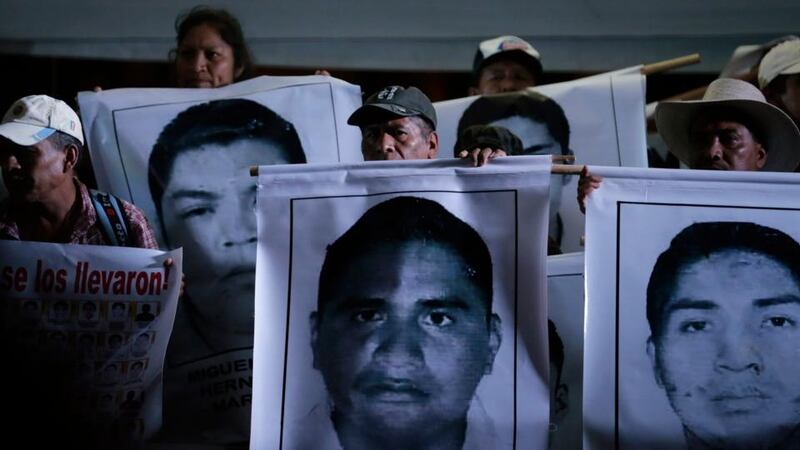 Relatives of the 43 missing students of the Ayotzinapa teachers’ training college hold pictures of the students, during a protest at Zocalo square in Mexico City last night. Photograph: Tomas Bravo/Reuters