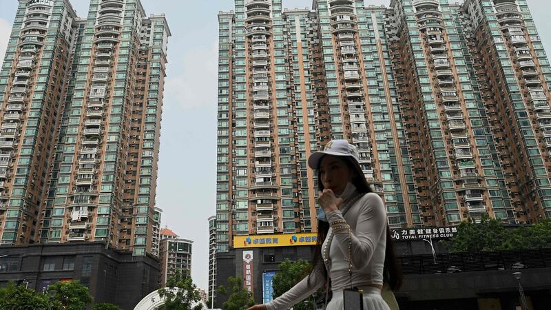 A woman walks past a housing complex built by Chinese property developer Evergrande in September. Photograph: Noel Celis/AFP via Getty Images