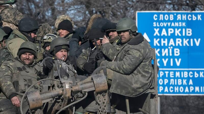 Ukrainian servicemen ride on a military vehicle as they leave the area around Debaltseve in  eastern Ukraine. Photograph: Gleb Garanich/Reuters.