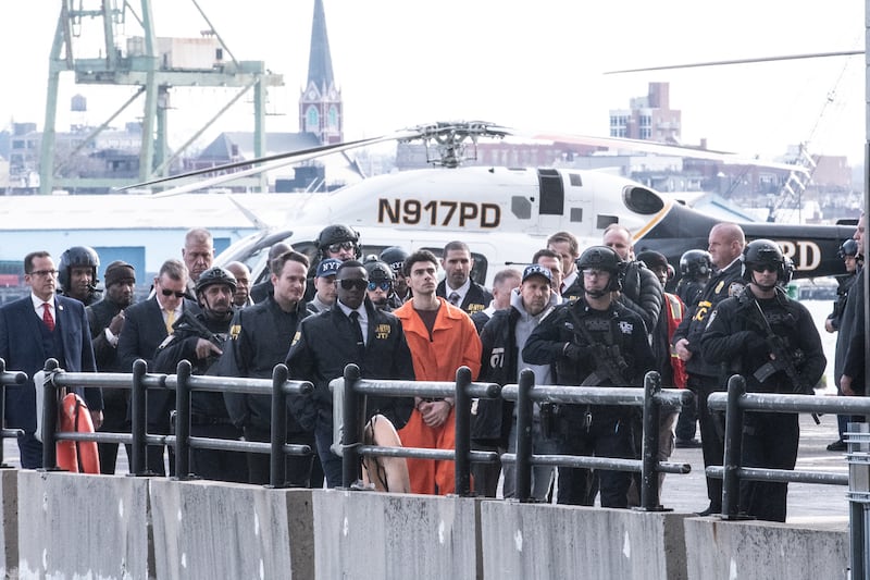 Luigi Mangione surrounded by law enforcement after arriving back in New York City. Photograph: Stephanie Keith/Getty Images