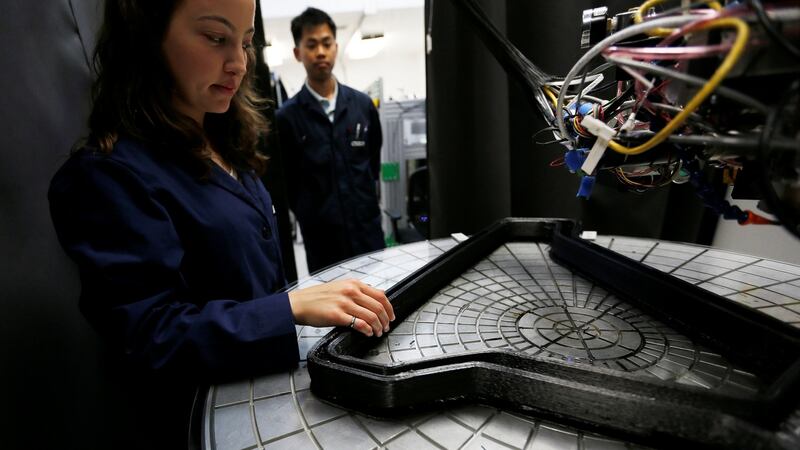 Engineers Magda Zydzik and Chris Lee of Arevo Labs inspect a carbon fibre bicycle frame in the process of being 3D-printed in Santa Clara, California