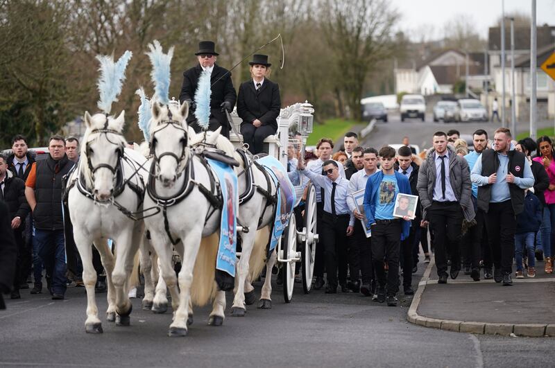 The horse-drawn carriage carrying the coffin of John Keenan arrives for his funeral at the Church of the Resurrection. Photograph: Niall Carson/PA