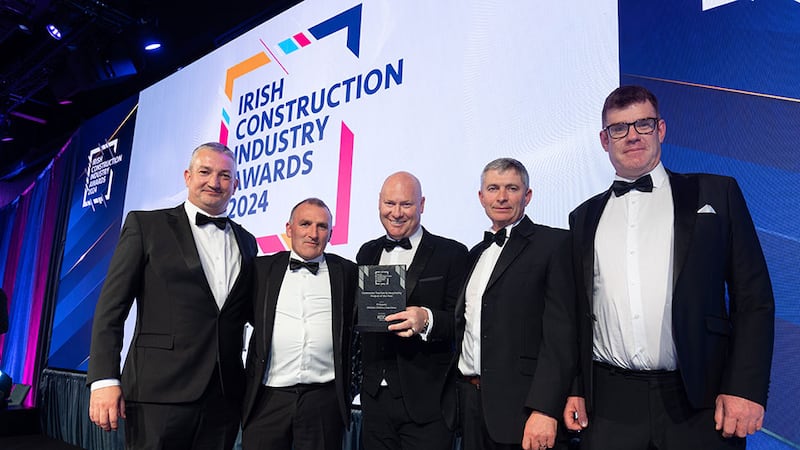 Stephen Arkins, director of sales at KCC Group, presents the contractor tourism & hospitality project of the year award to the PJ Hegarty team