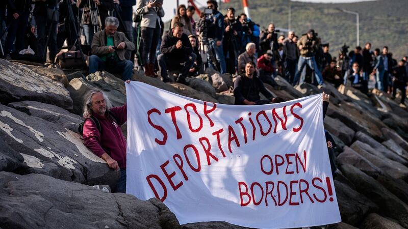 German activists show a banner during the arrival at Dikili port of a small Turkish ferry carrying migrants   deported to Turkey from Greece on Monday. Photograph: Ozan Kose/AFP/Getty Images