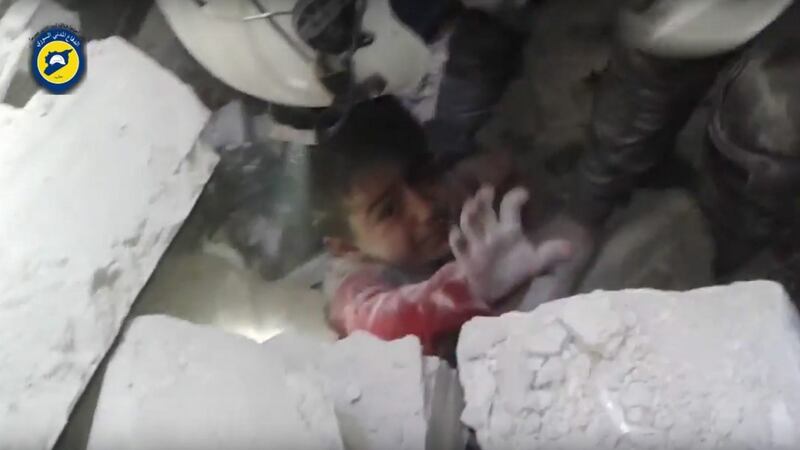 A handout frame grab from video footage released on  November 17th  by the Syrian Civil Defence, also known as the White Helmets, showing rescuers trying to pull out a child trapped under the rubbles of a building in the rebel-held Maadi neighbourhood of east Aleppo. Photograph:  EPA/White Helmets