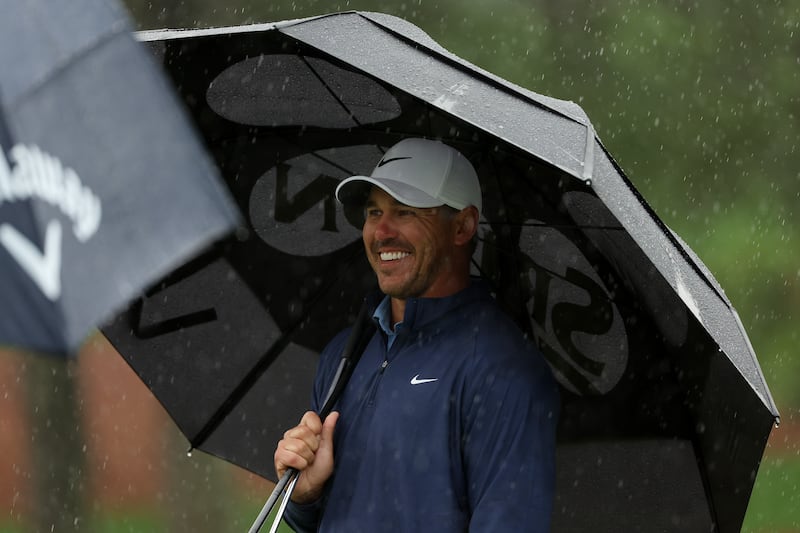 Brooks Koepka takes shelter from the rain at Augusta National. Photograph: Patrick Smith/Getty Images