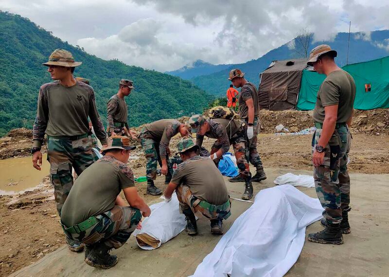 Soldiers wrap the bodies of victims of a mudslide in Noney. Photograph: Agui Kamei/AP