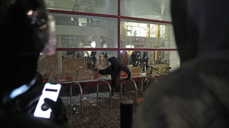 A protester kicks a smashed window at Bridewell Police Station  in Bristol on Sunday night. Photograph: Andrew Matthews/PA Wire