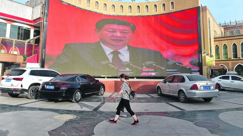 People walk past a screen showing images of China president Xi Jinping in Kashgar in China’s western Xinjiang region, in June, 2019. Photograph: Greg Baker/AFP)