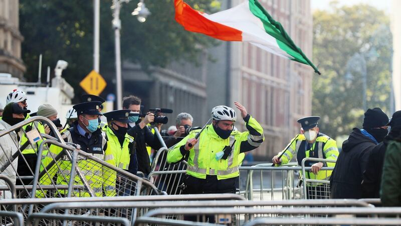 An Irish tricolour is thrown through the air while members of An Garda Síochána intervene as anti-lockdown protesters clashed with counter demonstrators during an anti-lockdown protest outside Leinster House on Saturday. Photograph: Brian Lawless/PA Wire