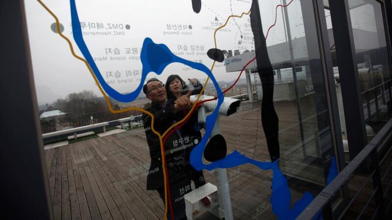 A couple looks at a map on a glass wall showing the  zone  which separates the two Koreas, at the Imjingak pavilion in Paju, north of Seoul. Photograph: Kim Hong-ji