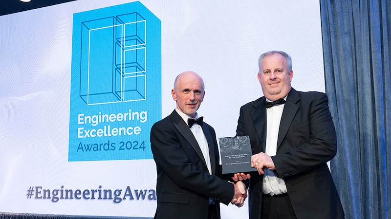 Michael Connelly, awards judge, presents the engineering firm of the year (50-100 employees) award to Richard O'Farrell, Engineering Design Consultants