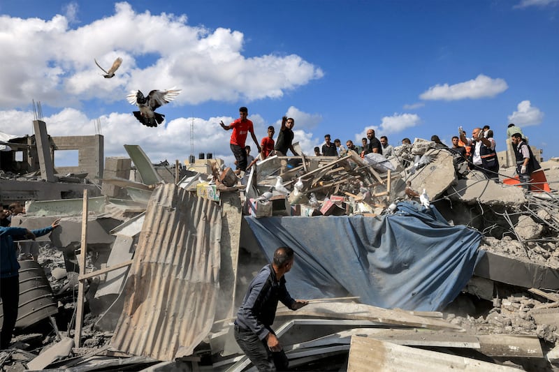 People inspect the remains of a destroyed building. A blast ripped through a hospital in war-torn Gaza killing hundreds of people late on October 17th (Photo by MAHMUD HAMS/AFP via Getty Images)