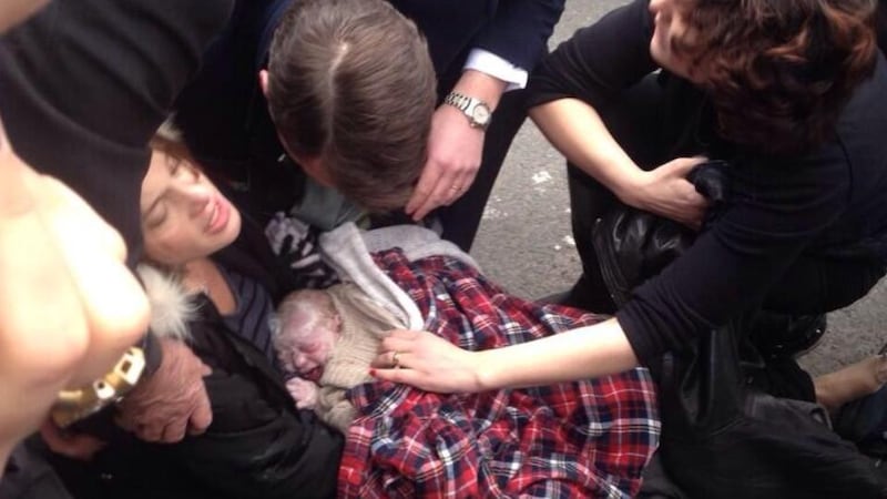 Unexpected: Polly McCourt and her baby just after Ila was born, on a New York street, on February 24th, 2014; Polly’s husband, Cian McCourt, is leaning over them