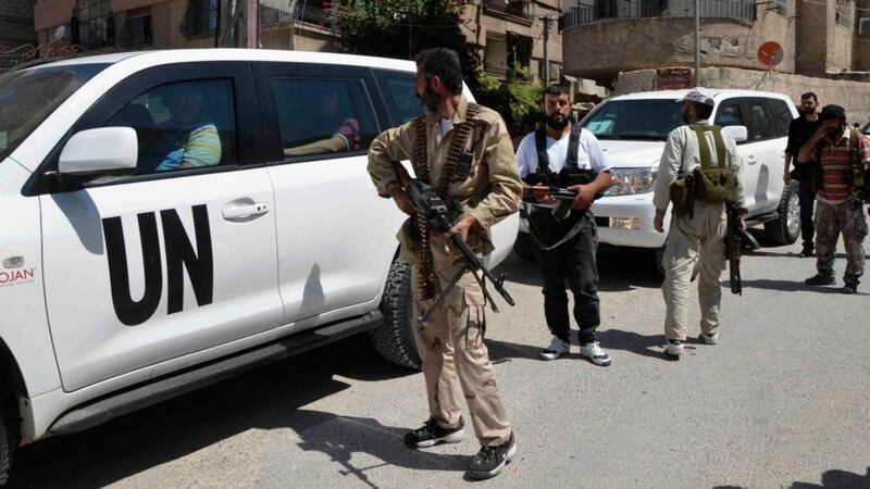 Free Syrian Army fighters carry their weapons as they escort a convoy of UN vehicles carrying a team of  chemical weapons experts  at one of the sites of an alleged chemical weapons attack in Damascus’ suburbs of Zamalka today. Photograph: Reuters