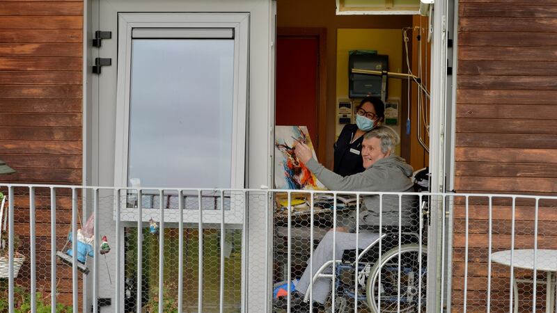 Eamon Hughes, a  resident of Teach Íosa, one of the community units at St Mary’s  Hospital in Phoenix Park,  painting one of the deer who visit outside his bedroom window, and healthcare worker Cecilia Roque. Photograph: Alan Betson/The Irish Times