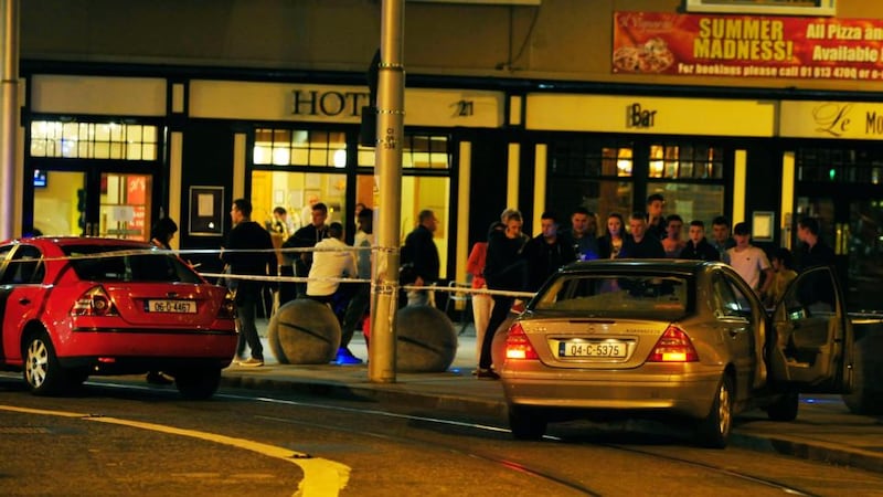 The scene outside Store Street Garda statation last night, where the back windscreen of a Mercedes was blown out and the driver’s door left open. A man was seen clutching his stomach and head as he ran into the Garda station. Photograph: Aidan Crawley