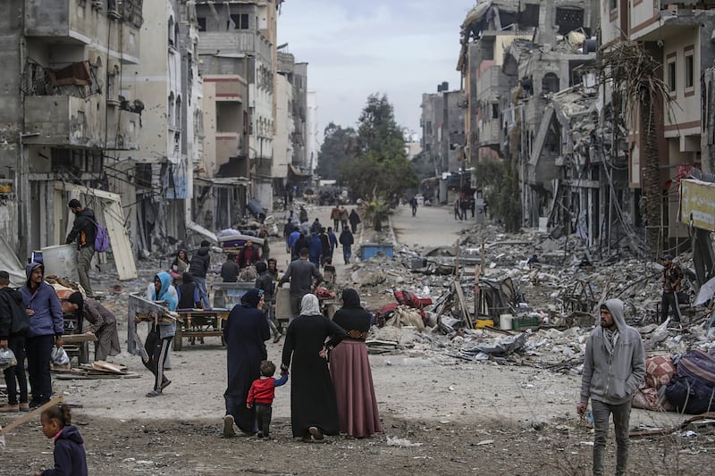 Palestinians walk along a street near the rubble of damaged buildings of Al Nuseirat refugee camp following an Israeli military operation at the camp, central Gaza Strip. Photograph: Mohammed Saber/EPA-EFE