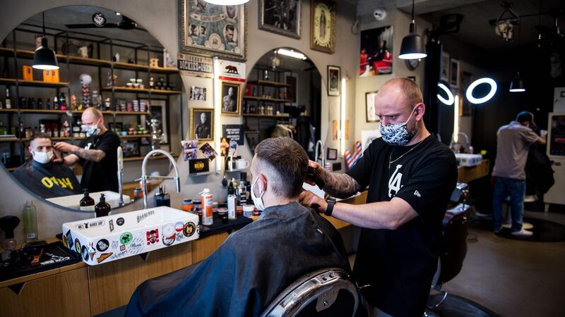 A barber cuts the hair of a client at a hairdressing salon in Bratislava, Slovakia on Tuesday. Irish people have been eager to learn when they might be able to go for a trim, according to Google search data. Photograph: Vladimir  Simicek/AFP via Getty Images.