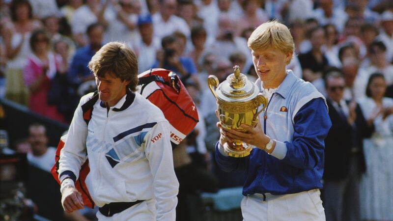 Boris Becker  looks at the names engraved on the trophy as he walks off court with Kevin Curren. Photograph:  Allsport/Getty Images