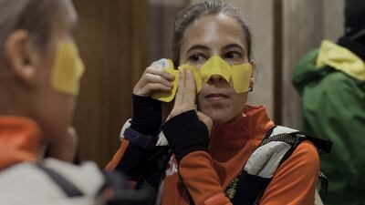 French runner Véronique Messina, attaches tape to protect her face from frostbite, on the morning of the Baikal Ice Marathon. Photograph: Emile Ducke/The New York Times