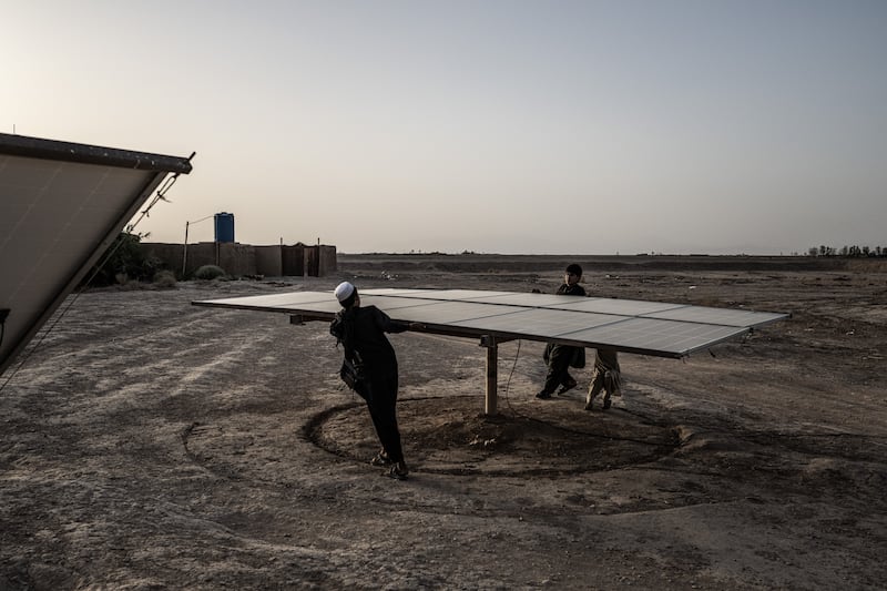 Relatives of Abdul Khaliq rotate a solar panel at the depot where he once prospered from fixing and selling the water pumps that enabled southwest. Photograph: Bryan Denton/The New York Times