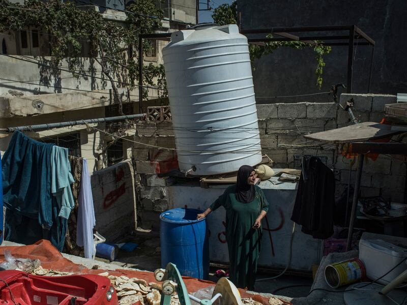 Ibtisam Yousef Abdelrahman, a Palestinian refugee who lives in the Wihdat camp in southeast Amman, stands on her rooftop in Jordan. Since her water tank broke in mid-September, she has had to rely on the kindness of her neighbours for water. Photograph: Laura Boushnak/The New York Times