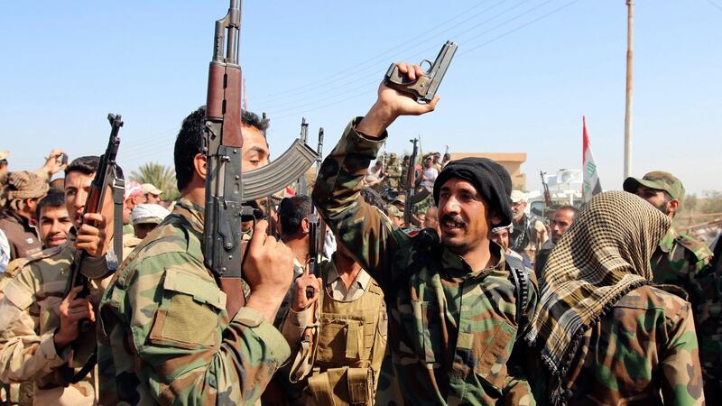 Iraqi security forces and Shia fighters chant slogans as they gather at Udhaim dam, north of Baghdad. Photograph: Thaier Al-Sudani/Reuters