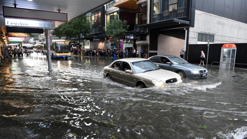 Cars attempt to drive through flood water in the Brisbane central business district  after a severe thunderstorm swept through the city. Photograph: Dan Peled/EPA.