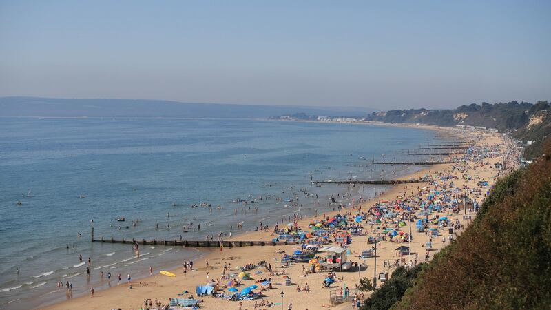 People on Bournemouth beach enjoy the sunshine which is set to continue throughout the long weekend. Photograph: PA